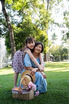 Happy grandmother with her granddaughter spending time together in park.