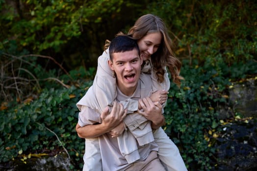 Young Cute Female Hugs Boyfriend. In Autumn Outdoor. Lovers Walking in Park. Attractive Funny Couple. Lovestory in Forest. Man and Woman. Cute Lovers in the Park. Family Concept. Happy Couple.