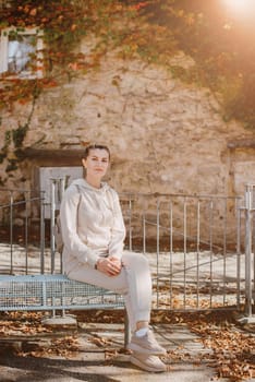 Attractive young woman sitting on a bench enjoying a view of medieval town in Europe. Summer holidays concept.