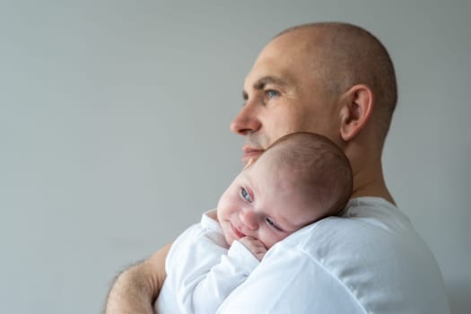 A man holds a baby in his arms. Parental care concept