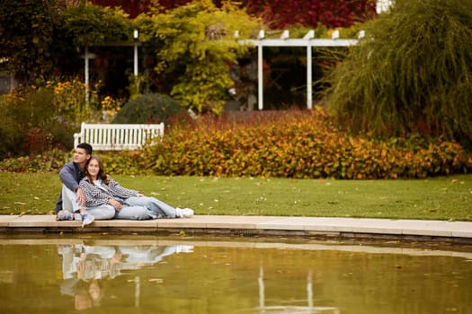 lovely young couple kissing outdoors in autumn. Loving couple walking in nature. Autumn mood. Happy man and woman hugging and kissing in autumn. Love. Fashionable couple outdoors. Fashion, people and lifestyle. Stylish couple in autumn outfit.