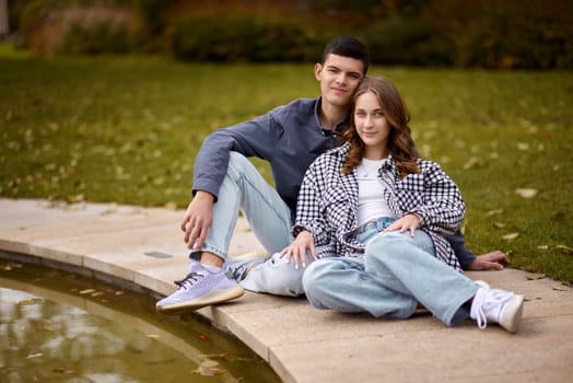 lovely young couple kissing outdoors in autumn. Loving couple walking in nature. Autumn mood. Happy man and woman hugging and kissing in autumn. Love. Fashionable couple outdoors. Fashion, people and lifestyle. Stylish couple in autumn outfit.