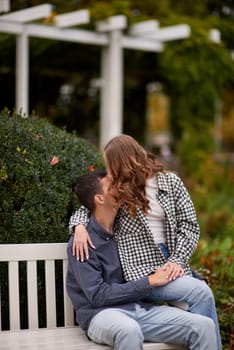 lovely young couple kissing outdoors in autumn. Loving couple walking in nature. Autumn mood. Happy man and woman hugging and kissing in autumn. Love. Fashionable couple outdoors. Fashion, people and lifestyle. Stylish couple in autumn outfit.