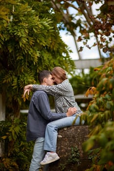 Joyful Autumn Embrace: Cute Lovers Strolling in the Park. Young Cute Female Hugs Boyfriend. In Autumn Outdoor. Lovers Walking in Park. Attractive Funny Couple. Lovestory in Forest. Man and Woman. Cute Lovers in the Park. Family Concept. Happy Couple.