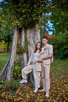 Young Cute Female Hugs Boyfriend. In Autumn Outdoor. Lovers Walking in Park. Attractive Funny Couple. Lovestory in Forest. Man and Woman. Cute Lovers in the Park. Family Concept. Happy Couple.