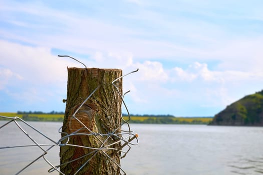 a barrier, railing, or other upright structure, typically of wood or wire