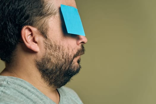 Facial portrait of a man with a beard in profile and covered with blank paper stickers