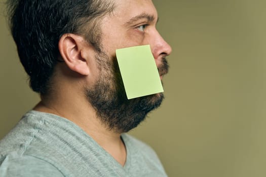 Facial portrait of a man with a beard in profile and covered with blank paper stickers