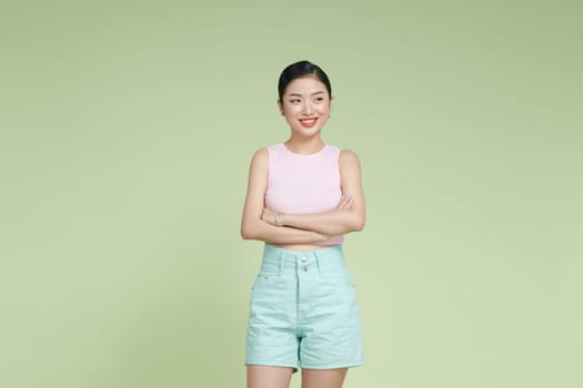 Confident nice smiling asian woman cross arms chest confident on light green background