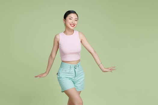 young beautiful Asian woman feeling joyful and relaxing dancing and smiling 