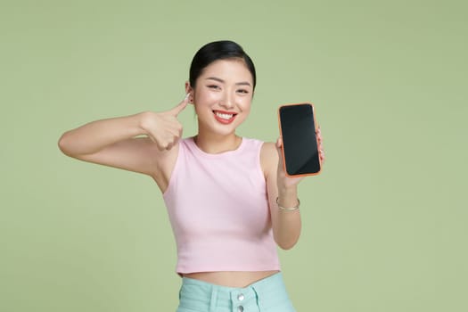 Satisfied happy asian girl show thumbs-up as demonstrate mobile phone screen application