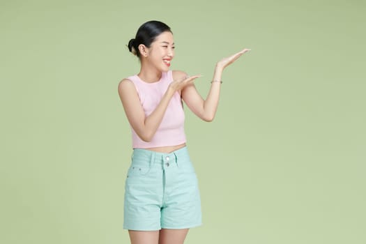Asian happy young woman smile standing presenting product holding something on palm away side,