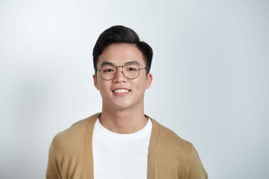 Close up portrait of young handsome Asian man face on light background