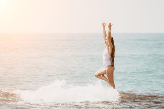 Woman sea yoga. Back view of free calm happy satisfied woman with long hair standing on top rock with yoga position against of sky by the sea. Healthy lifestyle outdoors in nature, fitness concept.