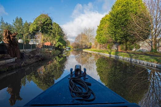 View from a narrowboat travelling in English rural countryside scenery on British waterway canal