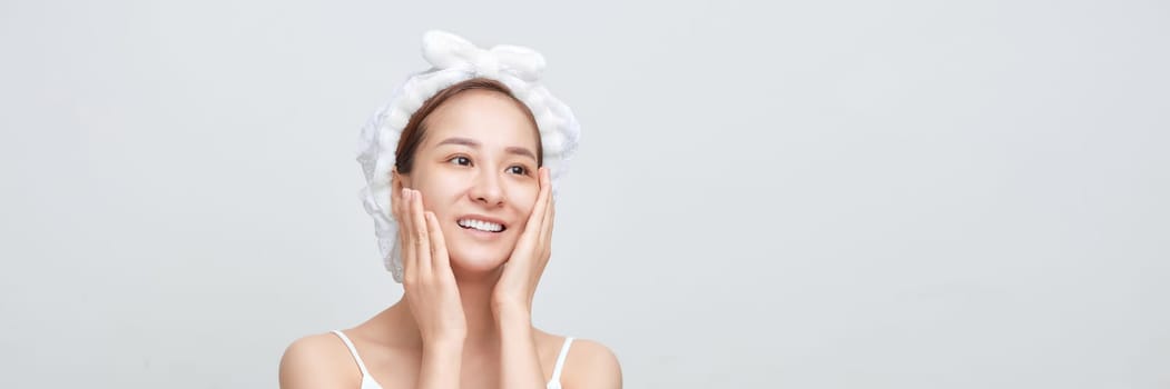 Happy confident young lady with towel on head touching moisturized soft healthy sensitive skin