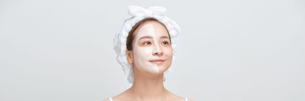 Banner of woman with a towel on her head apply a cleansing clay mask on her face