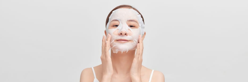 Banner of beautiful young woman applying rejuvenation facial mask on her face