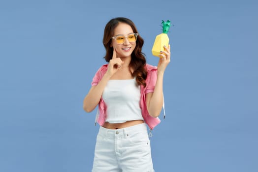 Young beautiful woman holding pineapple smiling