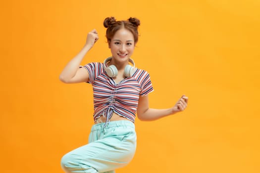 Carefree young woman enjoying favorite song, dancing and feeling free and happy.