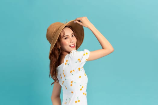 beautiful attractive stylish woman in straw hat posing on blue background 