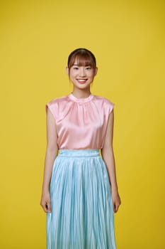 Young asian woman over isolated yellow background smiling