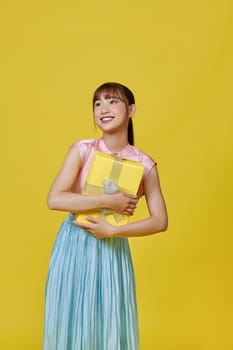 Emotional woman with gifts isolated on yellow. Holiday Sale.