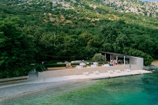 Festive tables stand on an open terrace in the garden above the sea. High quality photo