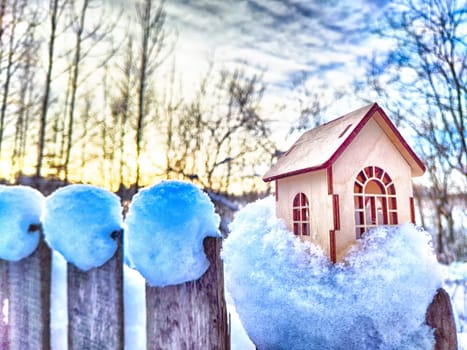 Wooden toy house on snow, natural abstract background. winter season concept. symbol of cozy, loving family home. construction, sales, rental concept. Christmas and new year holidays. copy space