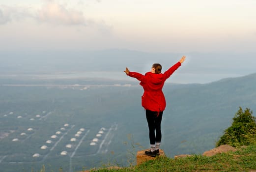 Caucasian beautiful woman stand with raise her arm up and action of happy with laughing with white sky as background.