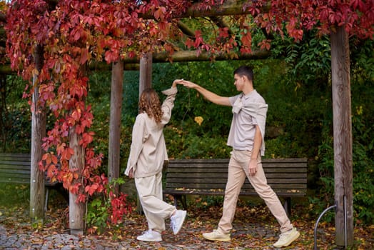 Young Cute Female Hugs Boyfriend. In Autumn Outdoor. Lovers Walking in Park. Attractive Funny Couple. Lovestory in Forest. Man and Woman. Cute Lovers in the Park. Family Concept. Happy Couple.