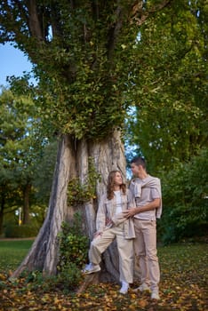 Young Cute Female Hugs Boyfriend. In Autumn Outdoor. Lovers Walking in Park. Attractive Funny Couple. Lovestory in Forest. Man and Woman. Cute Lovers in the Park. Family Concept. Happy Couple.