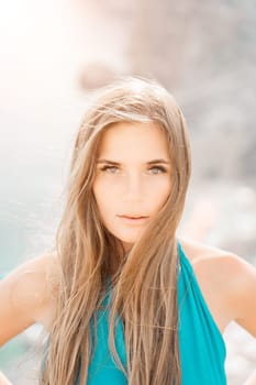 Woman sea green dress. Portrait of a happy woman with long hair in a long mint dress posing on a beach with calm sea bokeh lights on sunny day. Girl on the nature on blue sky background