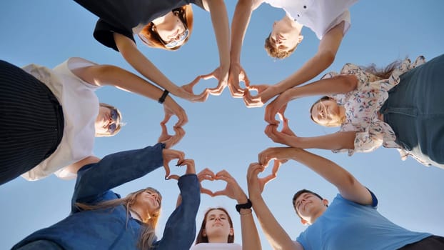Young friends stand in a circle and make hearts out of their hand wrists