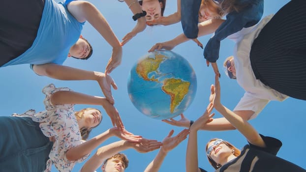 Students make a circle around the globe of the world. The concept of world peace
