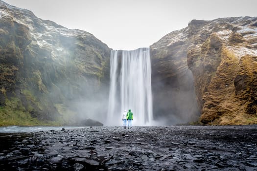 Couple back to back in Skogafoss, Iceland
