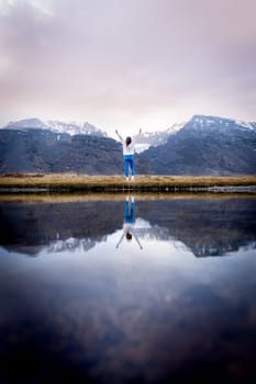 Woman posing by lake with her reflection in Iceland