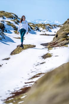 Woman walking on a snowy road on a sunny day in Iceland