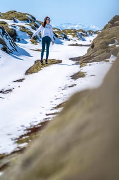 Woman walking on a snowy road on a sunny day in Iceland