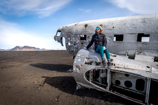 Woman posing in plane wreckage in Iceland