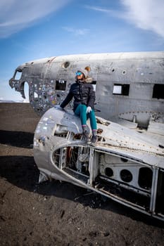 Woman posing in plane wreckage in Iceland