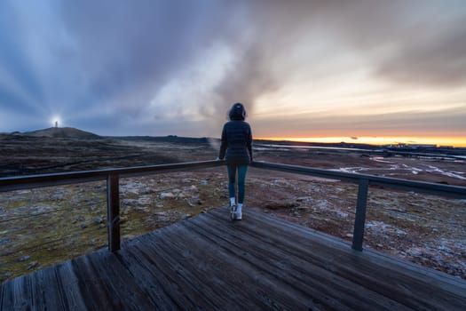 Woman posing at a lighthouse and smoky lands in Iceland