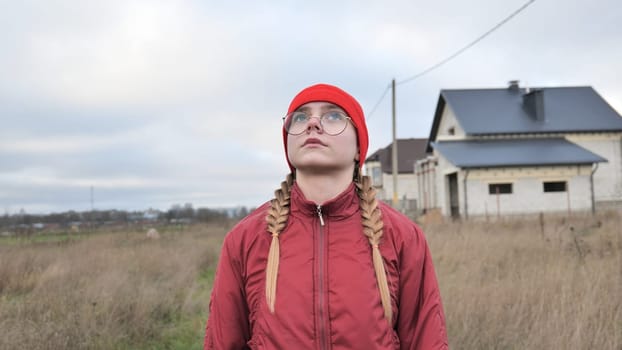 Portrait of a teenage girl in glasses wearing red clothes outside in the fall