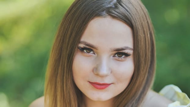 Portrait of a young girl in a park. Close-up of her face