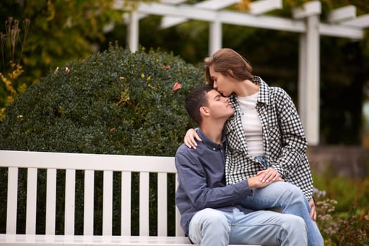 lovely young couple kissing outdoors in autumn. Loving couple walking in nature. Autumn mood. Happy man and woman hugging and kissing in autumn. Love. Fashionable couple outdoors. Fashion, people and lifestyle. Stylish couple in autumn outfit.