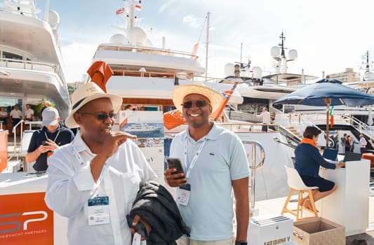 Monaco, Monte Carlo, 29 September 2022 - a lot of people, clients and yacht brokers look at the mega yachts presented, discuss the novelties of the boating industry at the famous motorboat exhibition. High quality photo