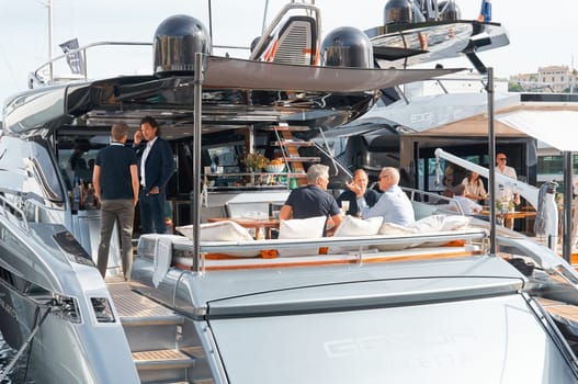 Monaco, Monte Carlo, 29 September 2022 - Invited wealthy clients inspect mega yachts at the largest fair exhibition in the world yacht show MYS, port Hercules, yacht brokers, sunny weather. High quality photo