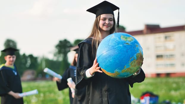 A graduate student poses with a globe in front of her friends