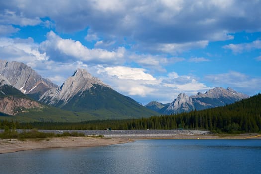 An incredible view of a natural mountain lake on a sunny summer day against the backdrop of the rocky mountains of Alberta in Canada