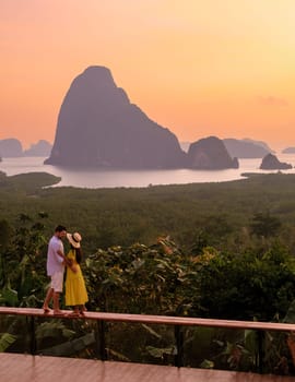 A couple of men and woman watching the sunrise at Sametnangshe viewpoint in Phangnga Bay with mangrove forest in the Andaman Sea , Sametnangshe travel destination in Phangnga, Thailand